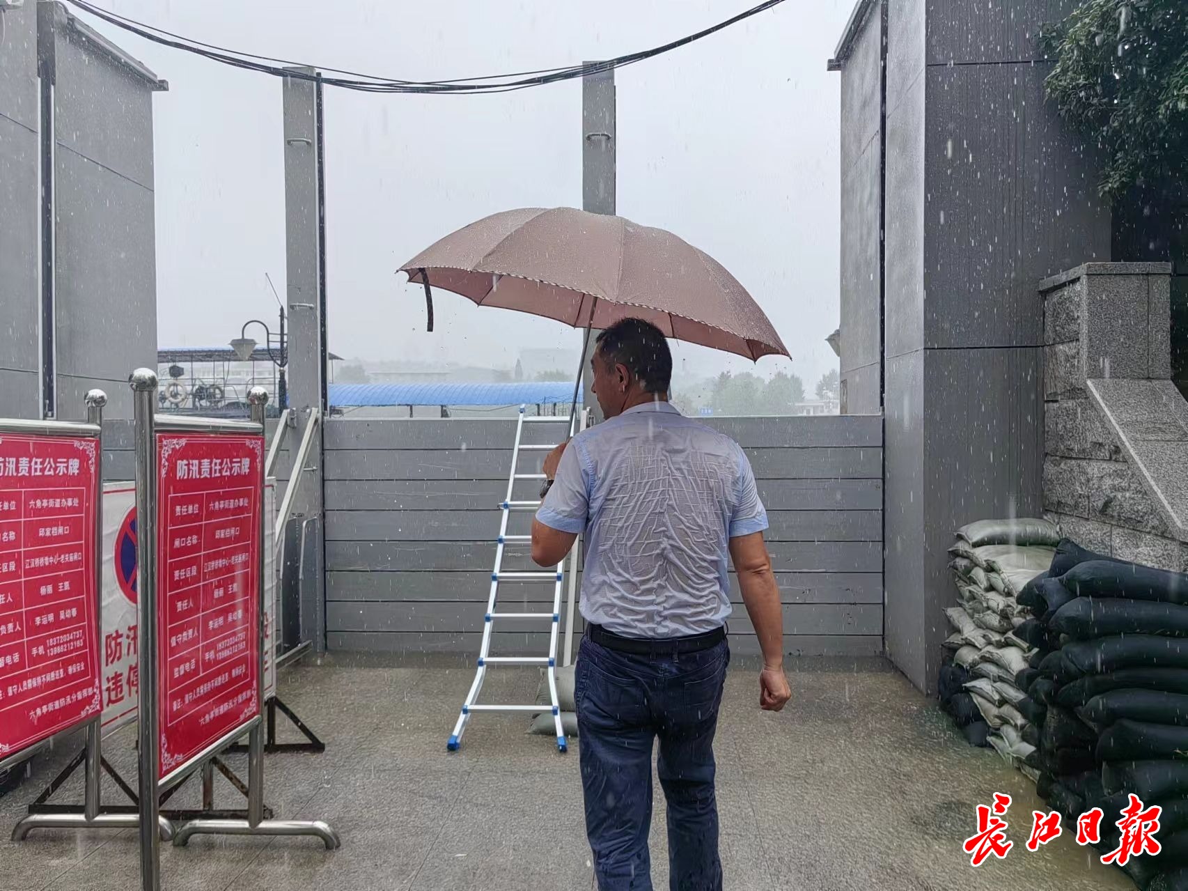 傾盆大雨中，水務工作人員衣服濕透。長江日報記者 金文兵 攝