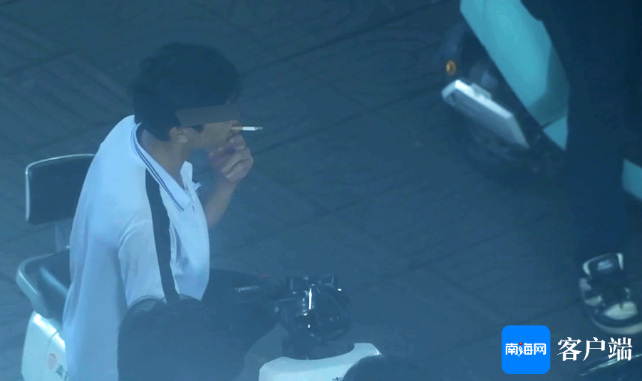 在便民服务亭旁抽烟的学生。记者 蒙健 摄