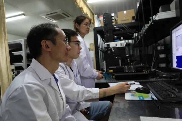 周华民(左一)和团队成员在做实验。周建元 摄