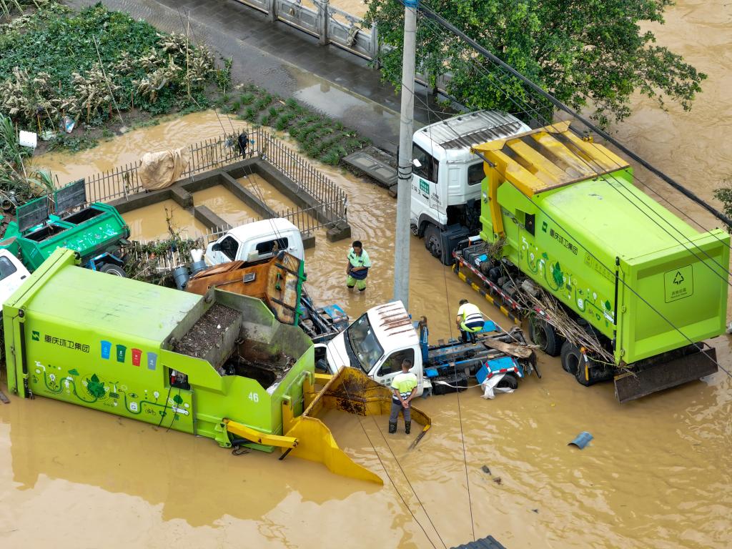 7月11日,重慶市墊江縣澄溪鎮,搶險人員對泡水車輛進行救援(無人機照片)。新華社記者 唐奕 攝