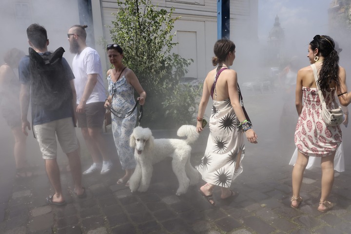 7月11日,在匈牙利布達佩斯,人們在噴霧裝置中感受清涼一刻。新華社發(弗爾季·奧蒂洛攝)