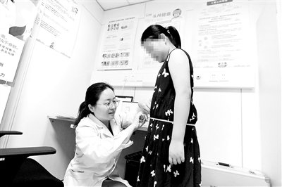 医生江倩为前来就诊的小朋友量腰围 摄影/本报记者 袁艺