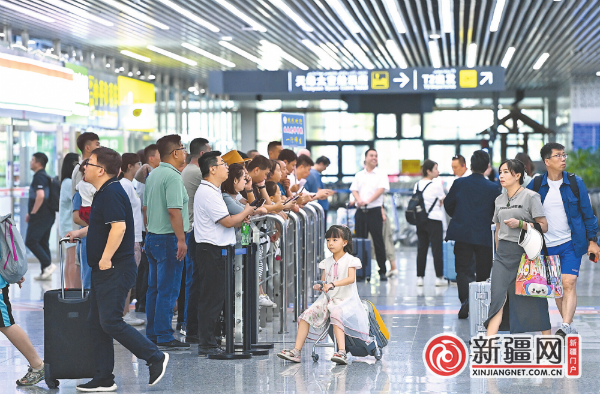 在乌鲁木齐地窝堡国际机场T2航站楼出站口,到港旅客有序出站。来源:乌鲁木齐晚报