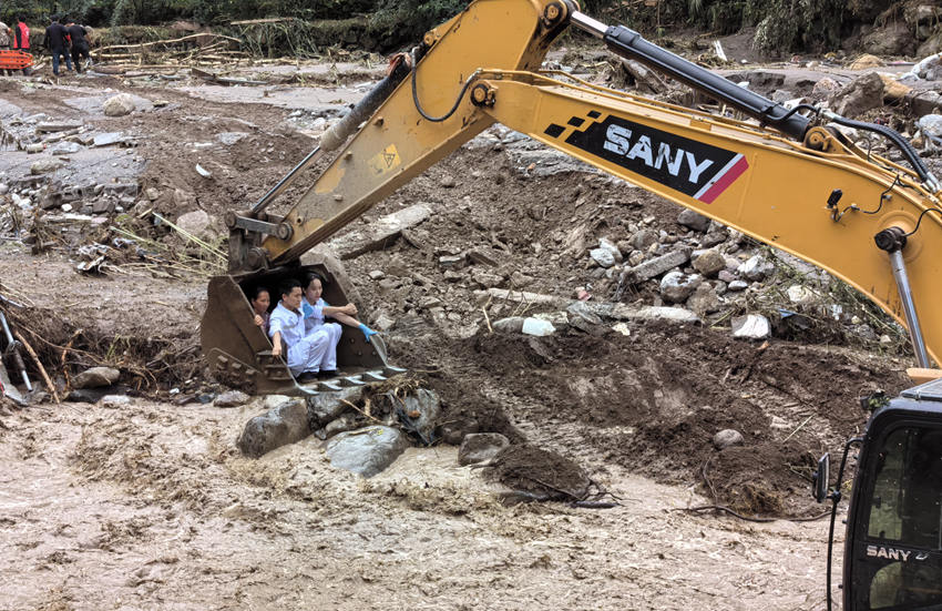 救援人員坐上挖掘機挖鬥轉運救治受災村民。雅安市120急救中心供圖