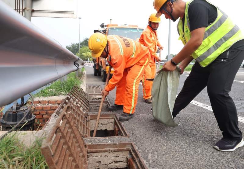 赶赴值守点位后,养护工人们再次清掏排水沟。新京报记者 王贵彬 摄