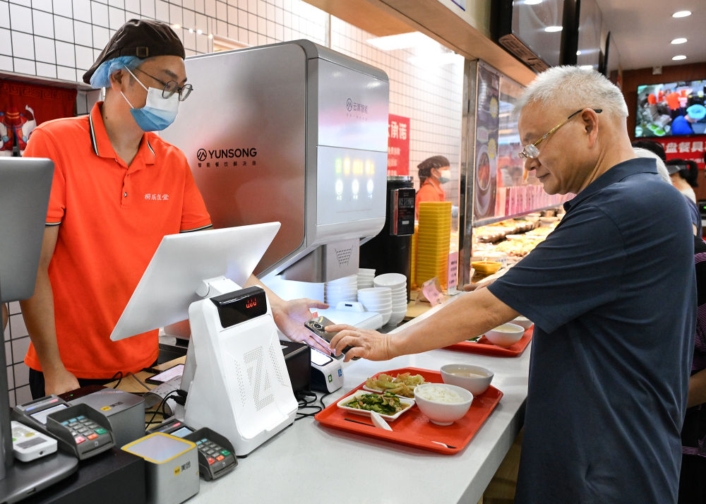 老人正在廣州桐樂社區飯堂買單（7月24日攝）。新華社記者 李賀 攝