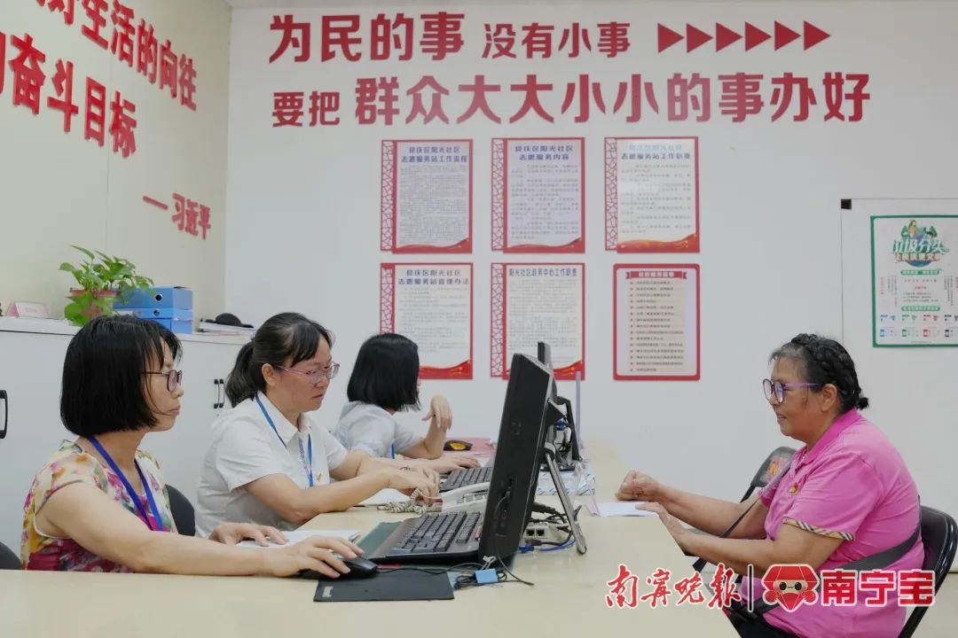 良庆区大沙田街道阳光社区工作人员在给居民办理业务。