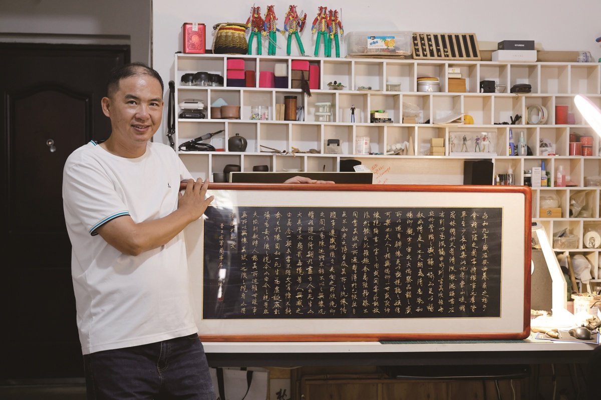 吴涛展示他制作的金属汉字书法作品。记者 苏华 摄