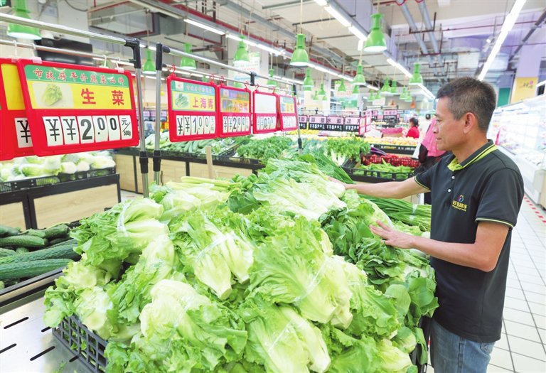 8月7日,员工在三亚解放四路旺毫超市整理特价蔬菜。记者 李学仕 摄