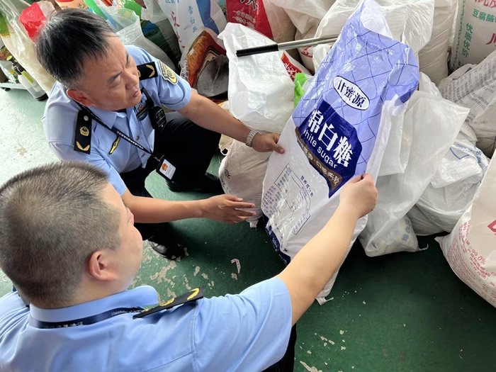 执法人员对相关品牌绵白糖产品的进货及销售情况开展调查取证。资料图片