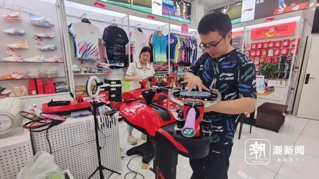 8月8日晚上,杭州余杭区一家店铺内,穿线师邵宗远(右一)正在为羽毛球拍换线。陶景成 摄
