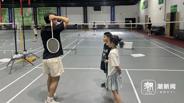 8月10日上午,杭州拱墅区一家羽毛球场馆内,教练正在挥拍培训教导羽毛球学员。记者 吴越 摄