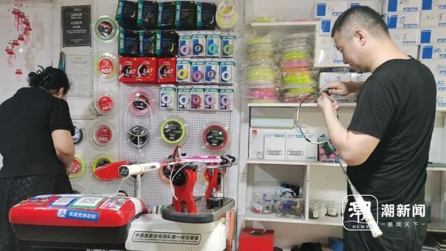 8月9日下午,杭州滨江区一家体育用品店里,穿线师刘海燕(左一)正在帮顾客取已经换好线的羽毛球拍。陶景成 摄