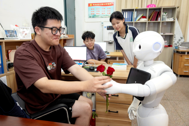 学生自主编程的机器人为教师赠送鲜花 谭云俸 摄