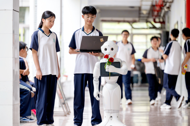学生操控自主编程的机器人在教学楼流动为教师赠送鲜花 谭云俸 摄