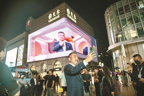 演员董勇在重装开业的雅戈尔上海时尚体验馆前自拍。
