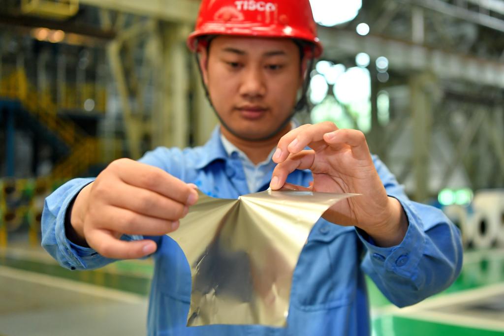 太鋼集團員工在展示用手撕開0.02毫米厚的超薄帶狀不鏽鋼(2019年5月24日攝)。新華社記者 曹陽 攝
