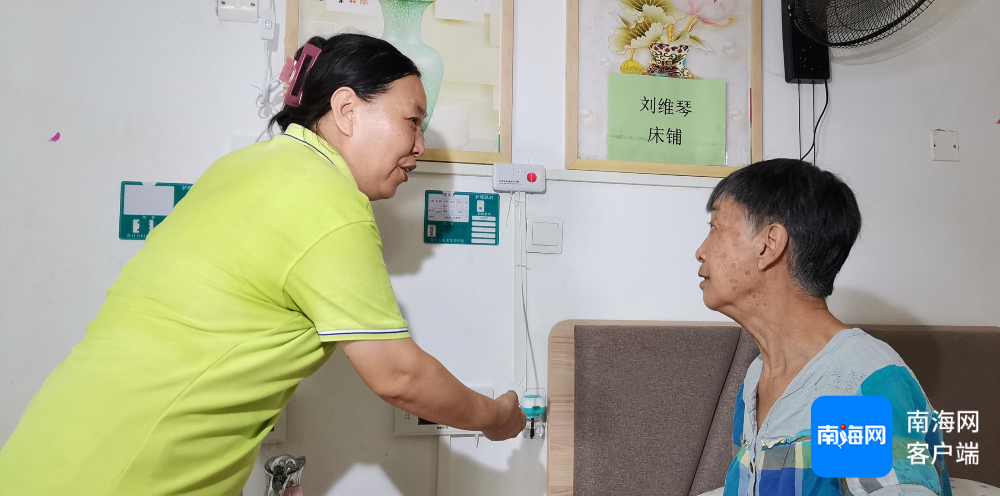 石山镇敬老院内助理人员宋辉在教老人使用床头边的紧急呼叫装置。记者 王康景 摄