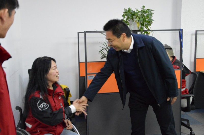 闫洪丰(右)与残疾人员工亲切交谈
