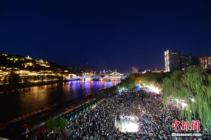 夕陽西下，夜幕降臨時分，黃河岸邊的廣場上「黃河大合唱」響徹夜空。圖/視覺中國