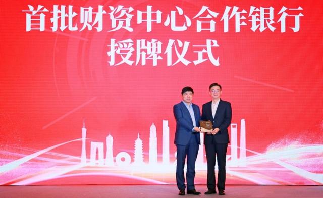 图片说明:陆家嘴管理局副局长梁庆(左)为工商银行上海分行结算与现金管理部总经理张濮灵(右)授牌