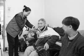 养老管家董秀艳(左)看望陈光明老人,为他测量血压。本报记者 王海欣 摄