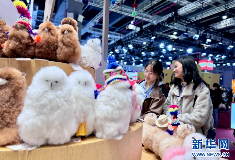 进博会上,顾客在选购羊驼玩偶。(新华网记者彭纯摄)