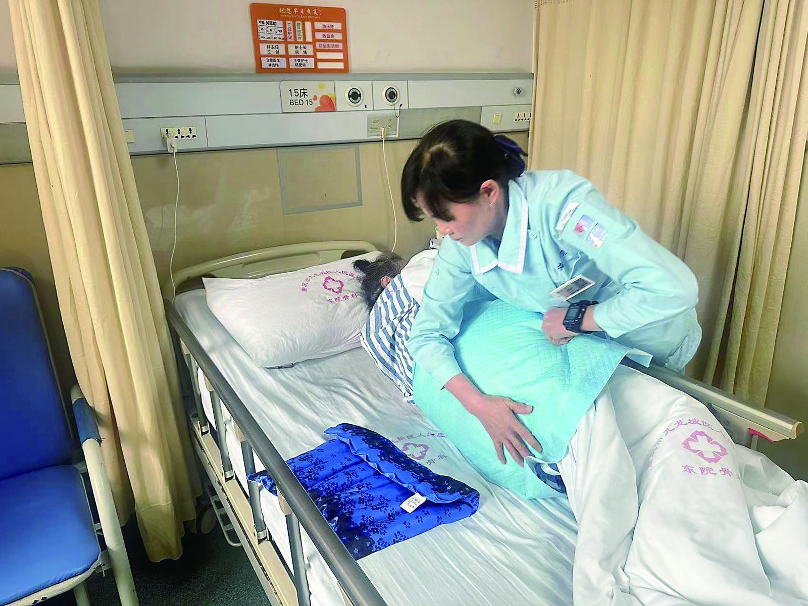 九龙坡区人民医院，医疗护理员马刚平正在教患者做康复训练。