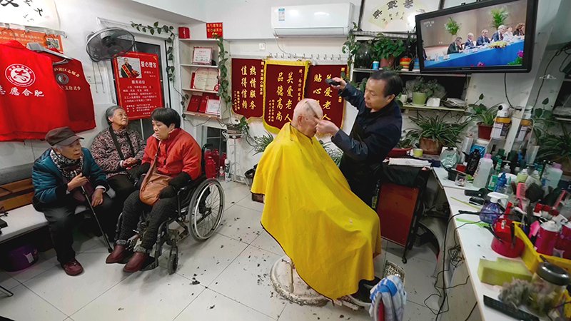 鄭祥生的理髮店裡，老人排隊理髮。廬陽區委宣傳部供圖