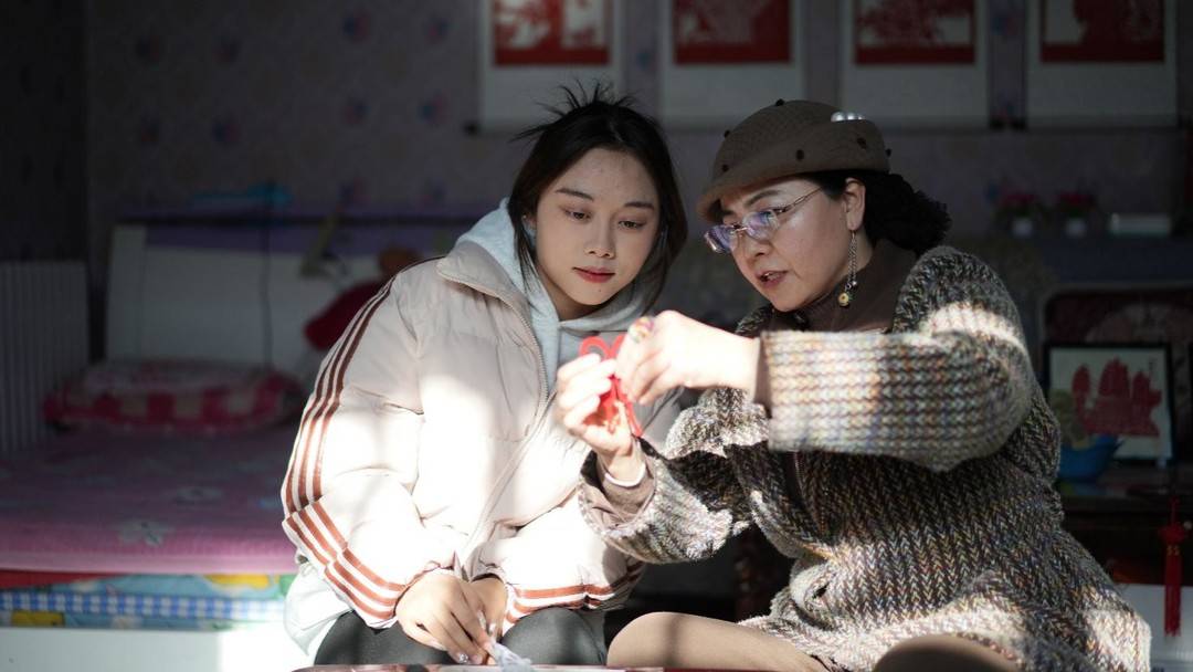 ▲買元花給女學員講解剪紙要領,她的剪紙培訓學校至今已累計培訓近5000人。莊晨晨 | 攝