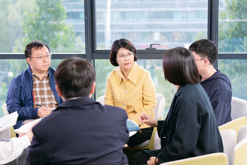 圖為2024年11月26日，單杏花與團隊成員討論務工人員團體票功能完善方案。 新華社發 桑治選兵/攝