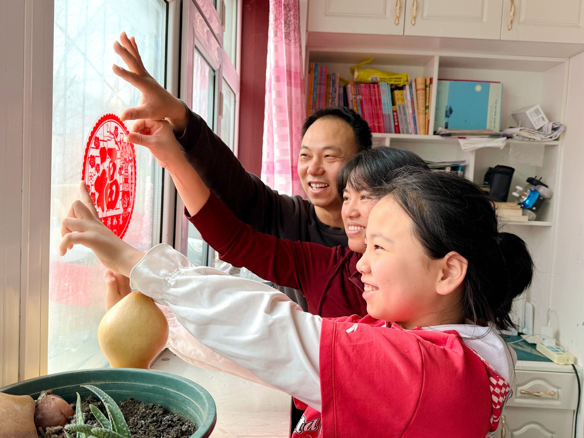 春節臨近，在八師一三四團光明路社區，市民在家中貼窗花、貼春聯，整個社區瀰漫著喜氣洋洋的祥和氛圍。雪峰 孔兆婧 攝