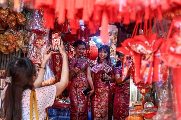 1月22日，緬甸仰光的年青人在當地年貨市場試穿旗袍，置辦春節新衣和裝飾品。視覺中國供圖