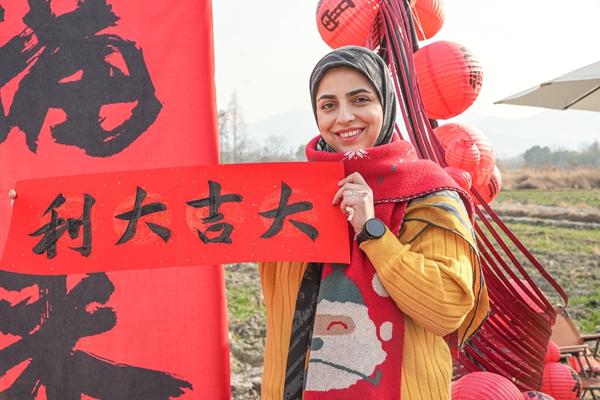 2025年1月20日，在浙江省湖州市德清縣舞陽街道太平村，外國友人展示剛寫好的春聯。視覺中國供圖
