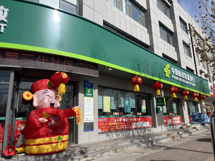 银行门口充气财神挥手迎宾,大喇叭循环播放春节特别活动