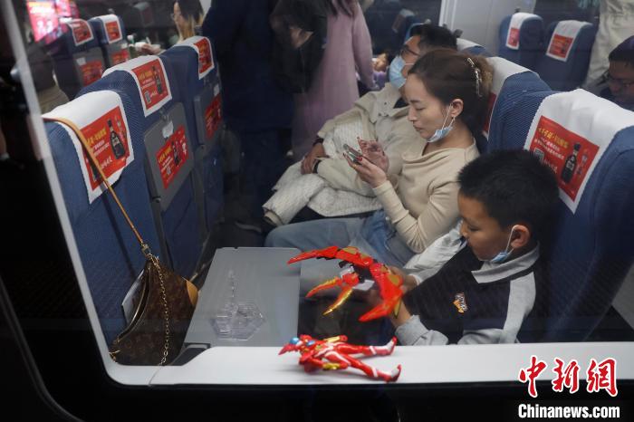 旅客帶著孩子乘坐高鐵列車前往自己的目的地。中新網記者 殷立勤 攝