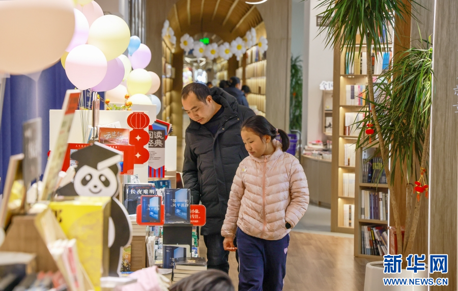在雲南省曲靖市麒麟區新華書店，家長帶著孩子選購書籍（2月5日攝）。新華網發（孫文來 攝）
