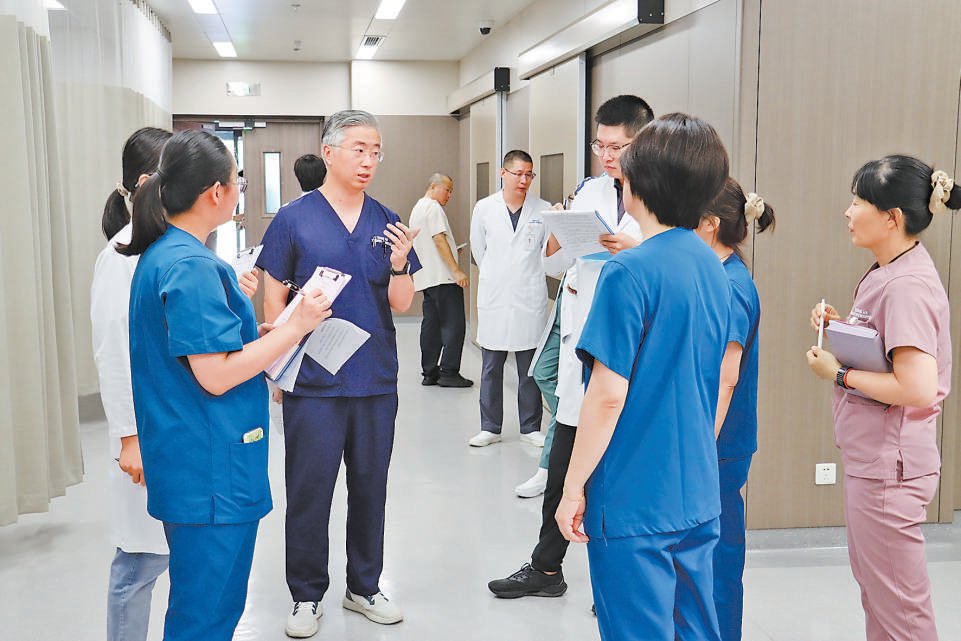 李嘉(右)與同事交流業(yè)務(wù)。受訪者供圖