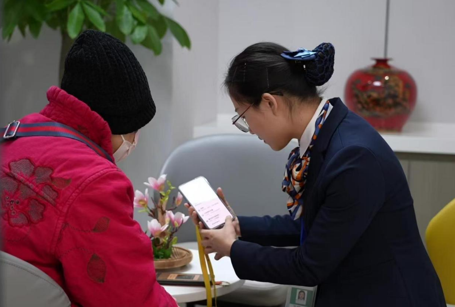 图为中国人寿旗下寿险公司柜面工作人员帮老年客户办理业务