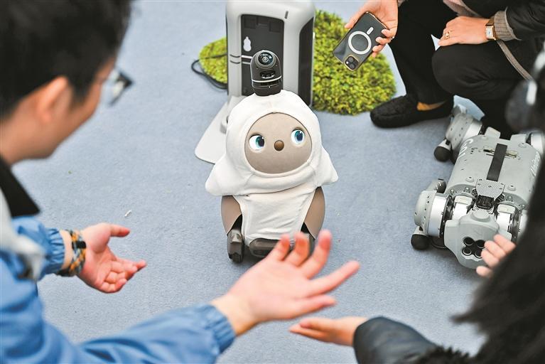 2月21日,觀眾在2025全球開發者先鋒大會現場與陪伴機器人互動。(新華)