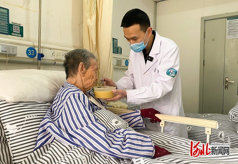 2月11日,河北省第八人民医院(河北省老年病医院)中西医结合科无陪护病房,护士张艺正在为患者喂饭。 河北日报记者 王木者摄