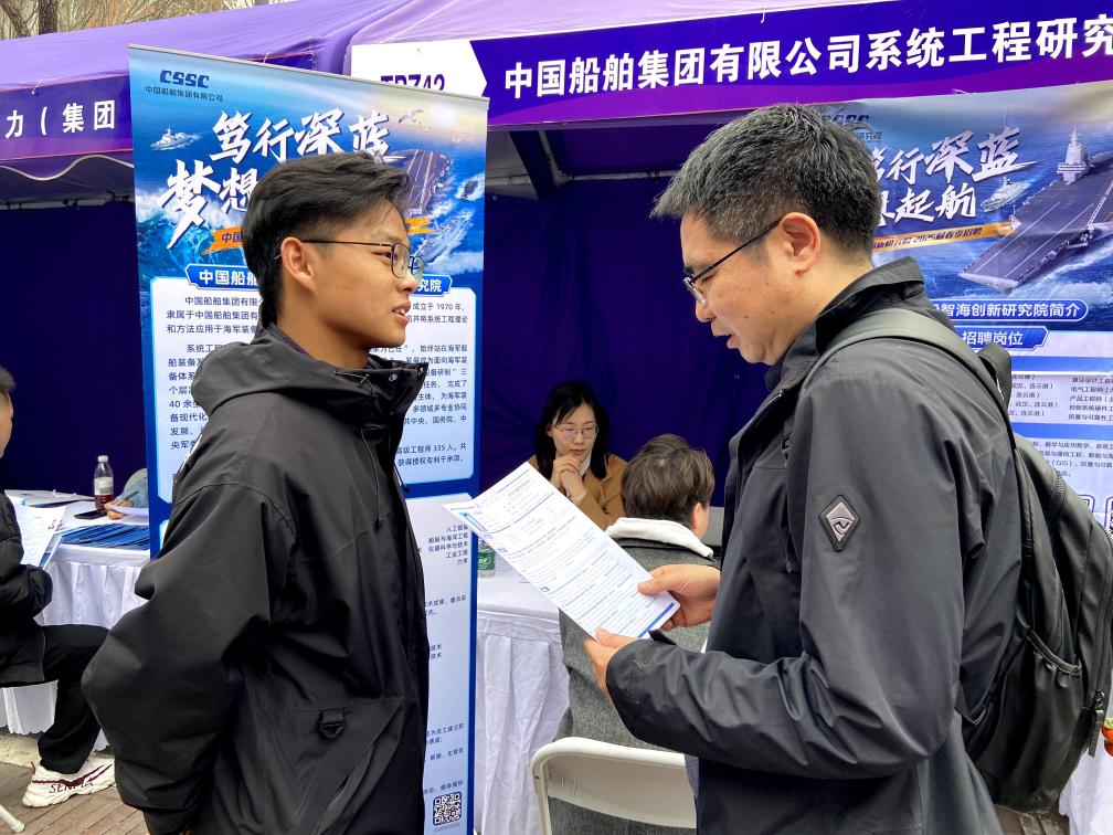北京交通大学博士毕业生齐天峰(左)与企业招聘人员交流。新华社记者 魏梦佳 摄