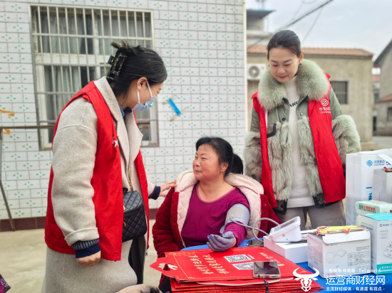(志愿者为居民提供免费测血压等服务)