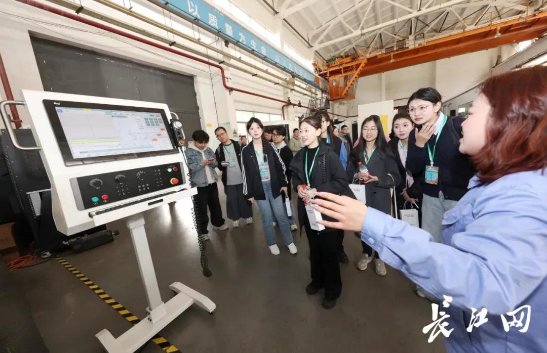 　　社会实践团成员在加工车间了解数控机床相关知识。王筝 摄