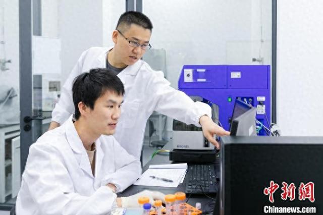 论文通讯作者李汉杰(后排)与论文第一作者吴志生交流实验结果。深圳先进院供图