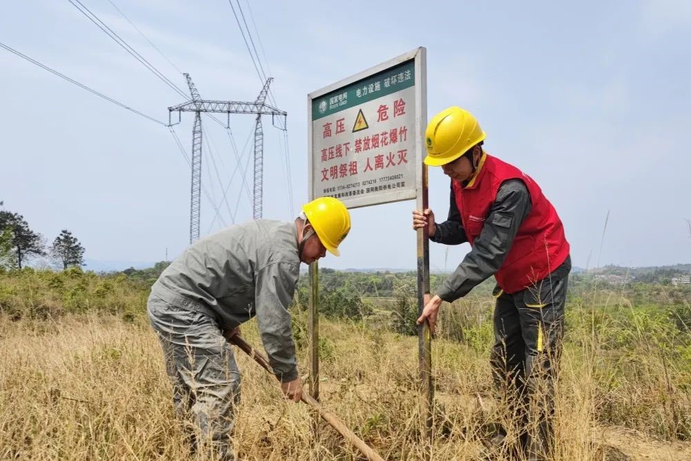 国网湖南电力员工在220千伏印柏线101、102号塔间竖立防山火警示牌