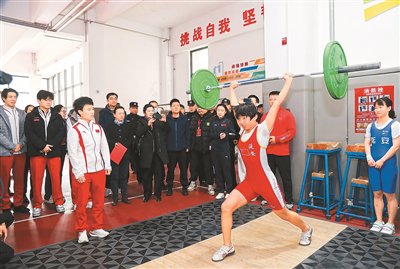 侯誌慧(前排左一)在指導小運動員練習舉重動作。活動方供圖