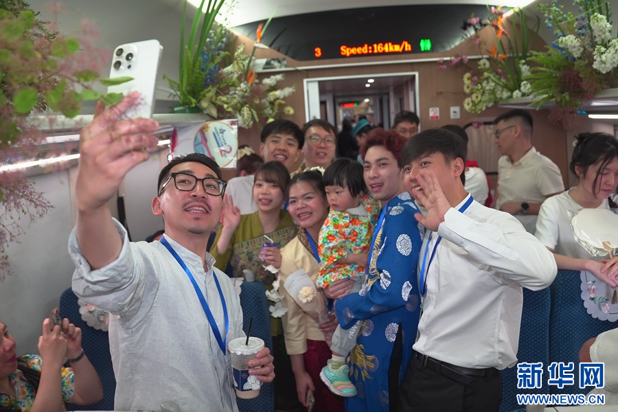 4月12日,D87次國際旅客列車上,來自昆明鐵道職業技術學院的留學生與旅客合照留念。新華網發(周濤 攝)