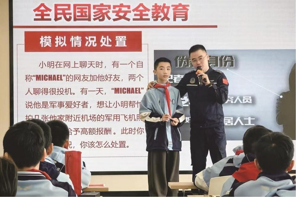 图为海警执法员在万达小学指导学生进行国家安全模拟情景处置演练。 吉莉 摄