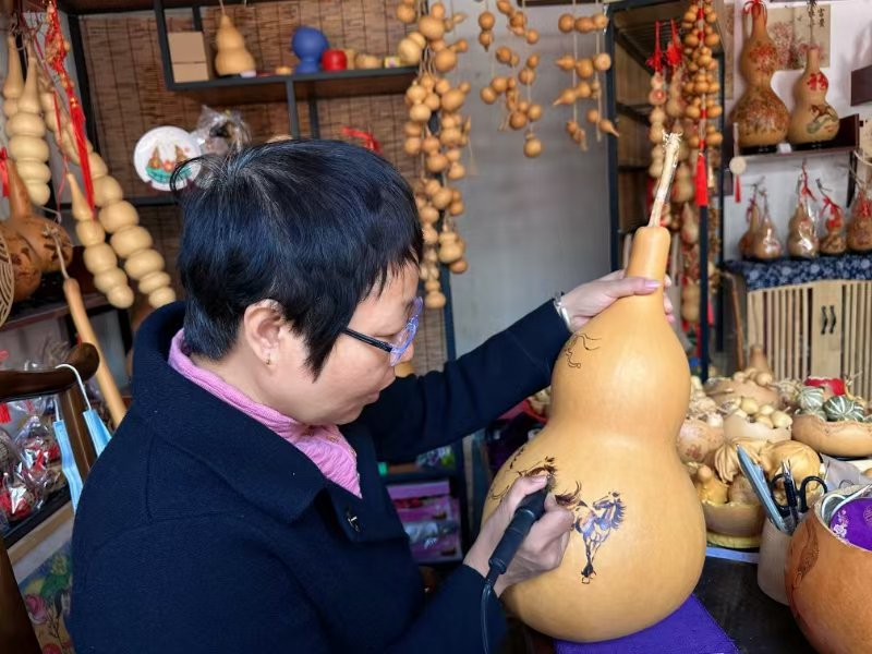 忻州古城葫蘆烙畫店舖內,李雲珍正在創作《八駿圖》。人民網記者 麻潞攝